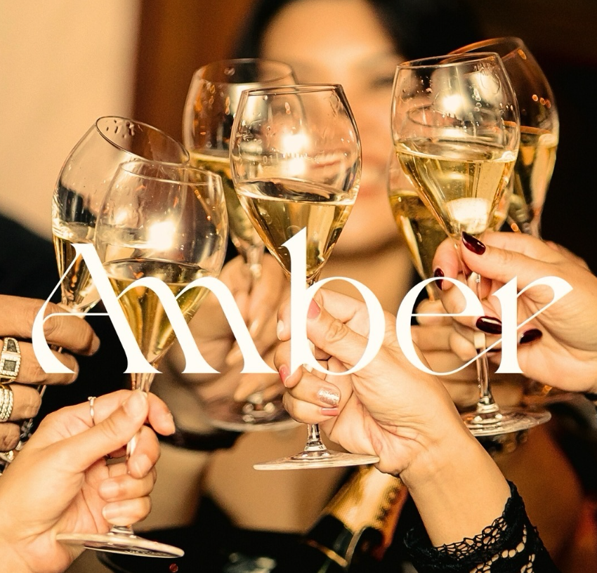 Guests raising champagne glasses in a toast at AMBER