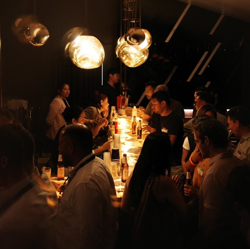 Guests gathered along AMBER's glowing amber-lit bar