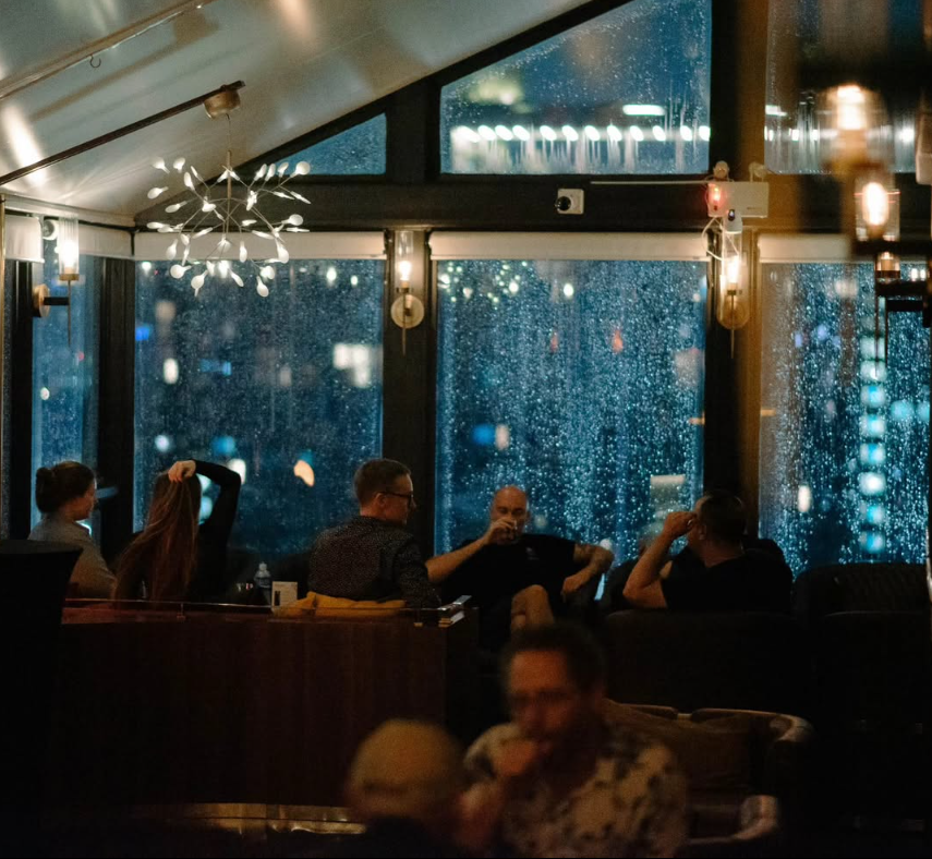 Lounge seating beside floor-to-ceiling windows over Bangkok